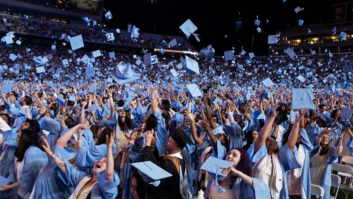 学生们在凯南体育场的毕业典礼上投掷帽子